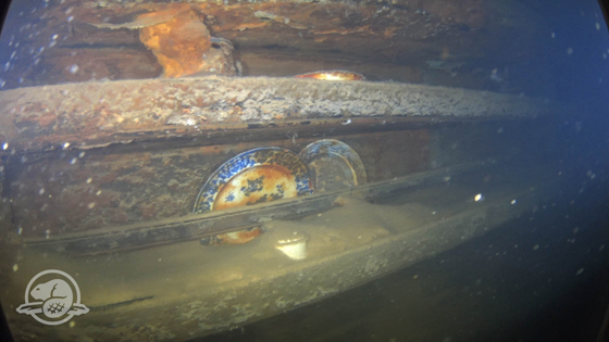 Teller und andere Artefakte auf einem Regal nahe des Essplatzes der Mannschaft
 © Parks Canada, Underwater Archaeology Team  