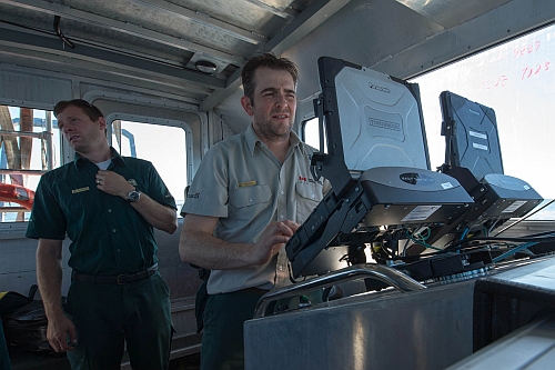 Ryan Harris am Navigationscomputer des Forschungsbootes– Foto: Jonathan Moore  © Parks  Canada