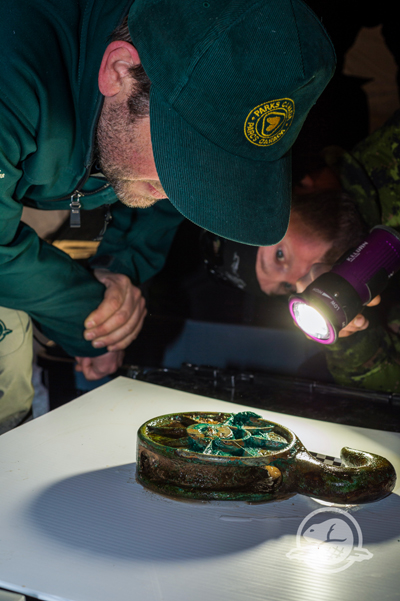 Ryan Harris mit einem von HMS Erebus geborgenen Seilzughaken  – Courtesy of Parks Canada